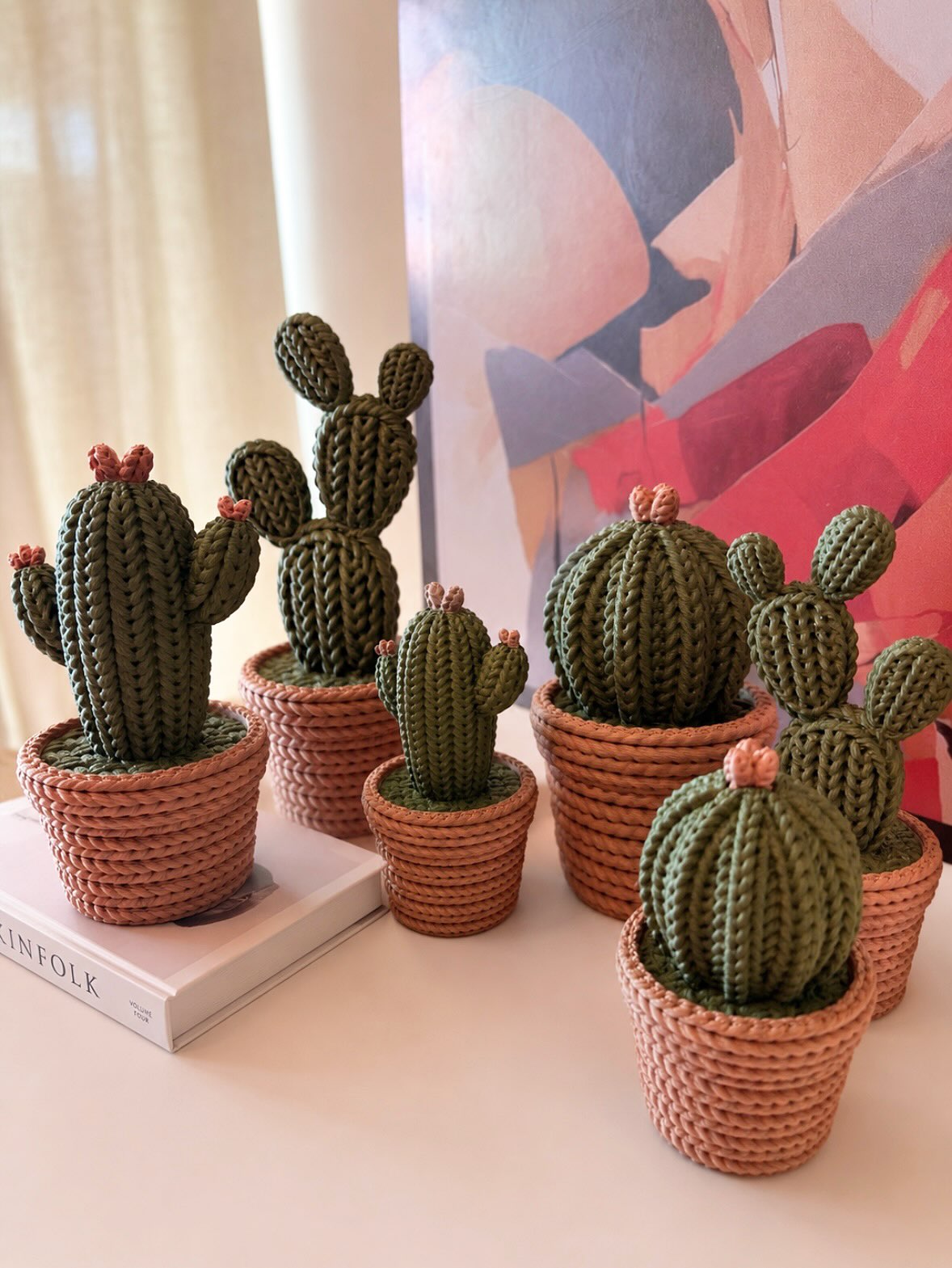 Cactos impressos em 3D em fileira sobre estante